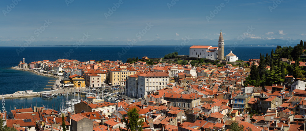 Panorama of Piran Slovenia on Gulf of Trieste Adriatic sea from the Cape Madonna St Clement church to St George's Cathedral with Kanin Mountains Panorama of Piran Slovenia on Gulf of Trieste Adriatic sea from the Cape Madonna St Clement church to St George's Cathedral with Kanin Mountains
