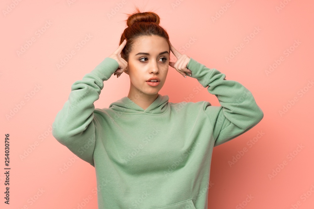 Young redhead woman with sweatshirt having doubts and thinking