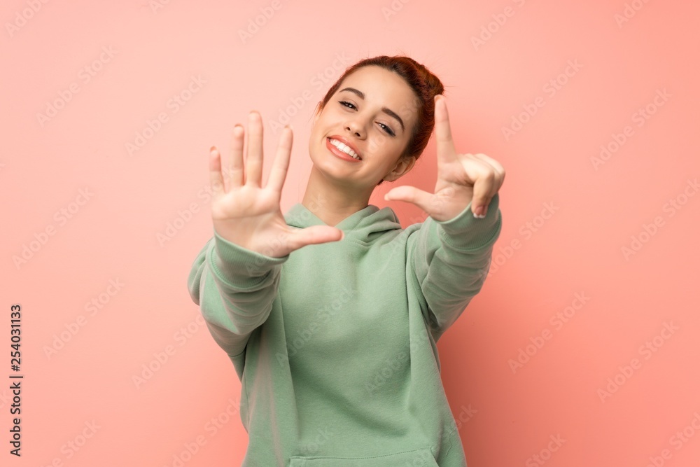 Young redhead woman with sweatshirt counting seven with fingers Young redhead woman with sweatshirt counting seven with fingers