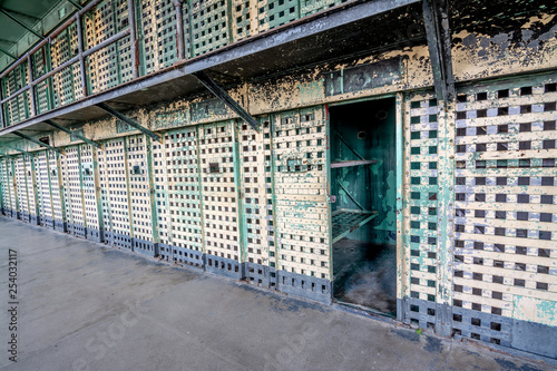Prison cell block of barred doors and one is open