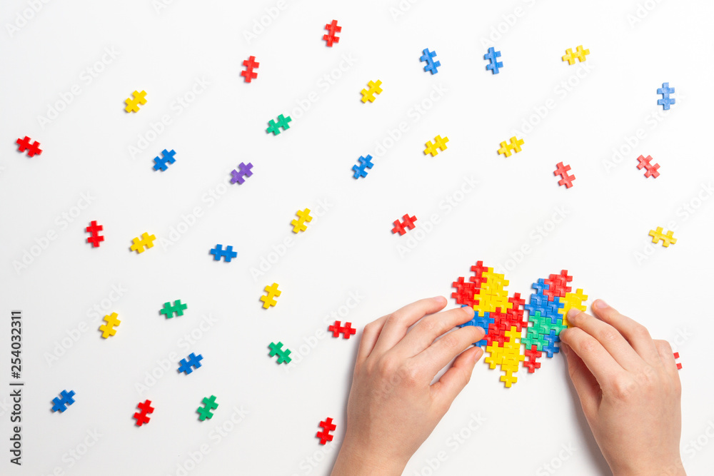 Child hands making multicolored heart on white background. Top view Child hands making multicolored heart on white background. Top view