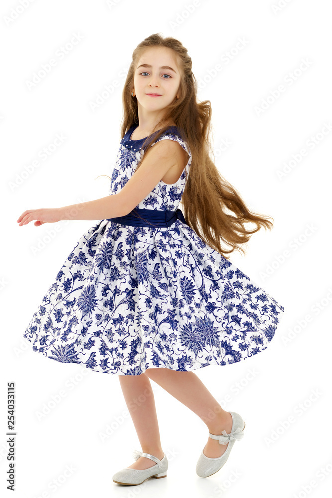 A little girl in a dress is spinning. A little girl in a dress is spinning.