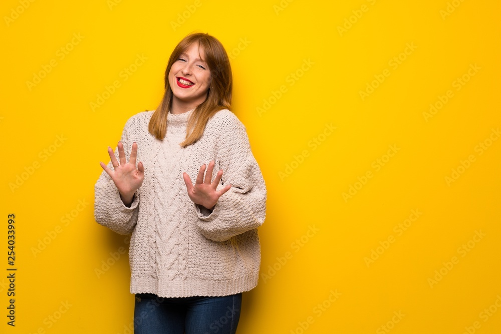 Redhead woman over yellow wall smiling Redhead woman over yellow wall smiling