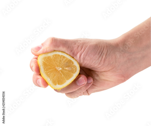 Hand squeezes lemon juice close - up on a white. Isolated.