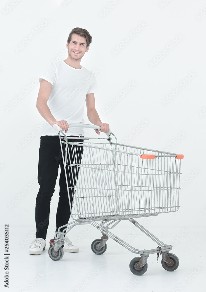 young man pushes an empty shopping cart young man pushes an empty shopping cart
