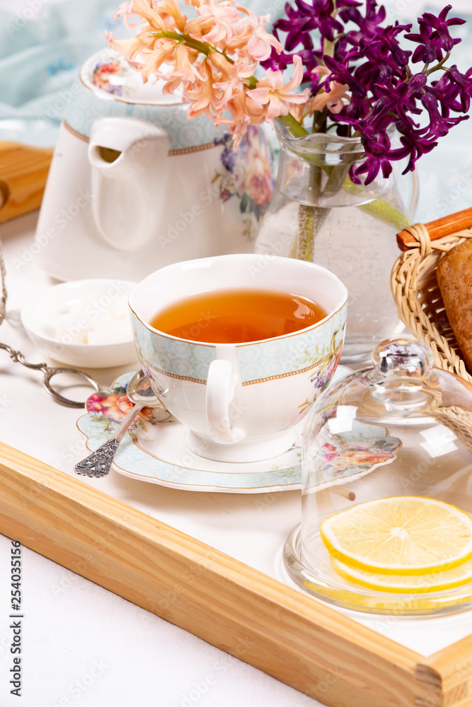 Morning tea concept. Flowers, tea and strudel on a tray