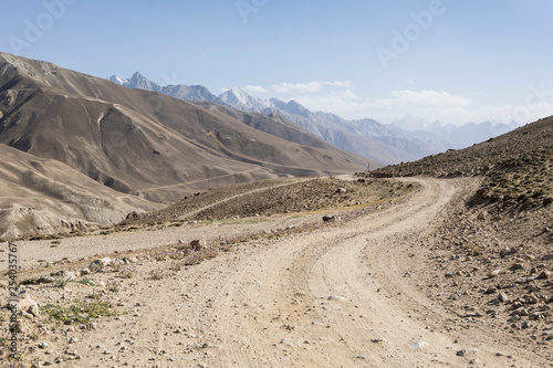 Pamir Highway in the desert landscape of the Pamir Mountains in Tajikistan. Afghanistan is on the left