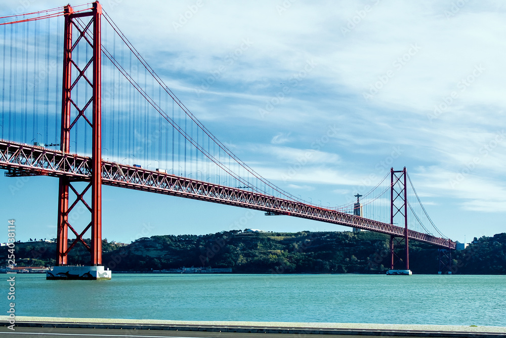 Fototapeta premium 25th of April Bridge over the Tagus river, connecting Almada and Lisbon in Portugal