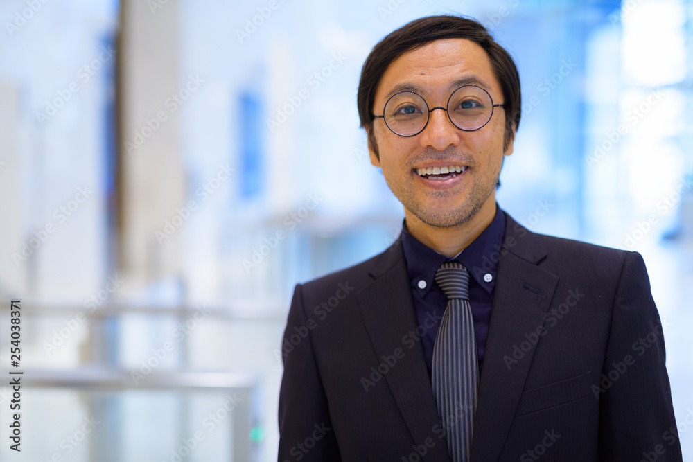 Fototapeta premium Face of happy Asian businessman smiling inside the office building