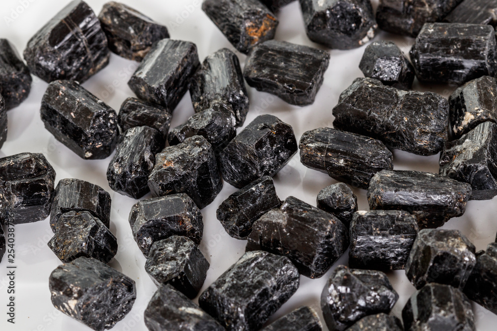 macro mineral stone schorl, black tourmaline on white background macro mineral stone schorl, black tourmaline on white background