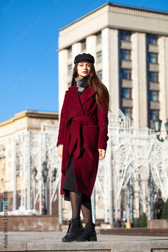 Beautiful girl in stylish in a long burgundy coat