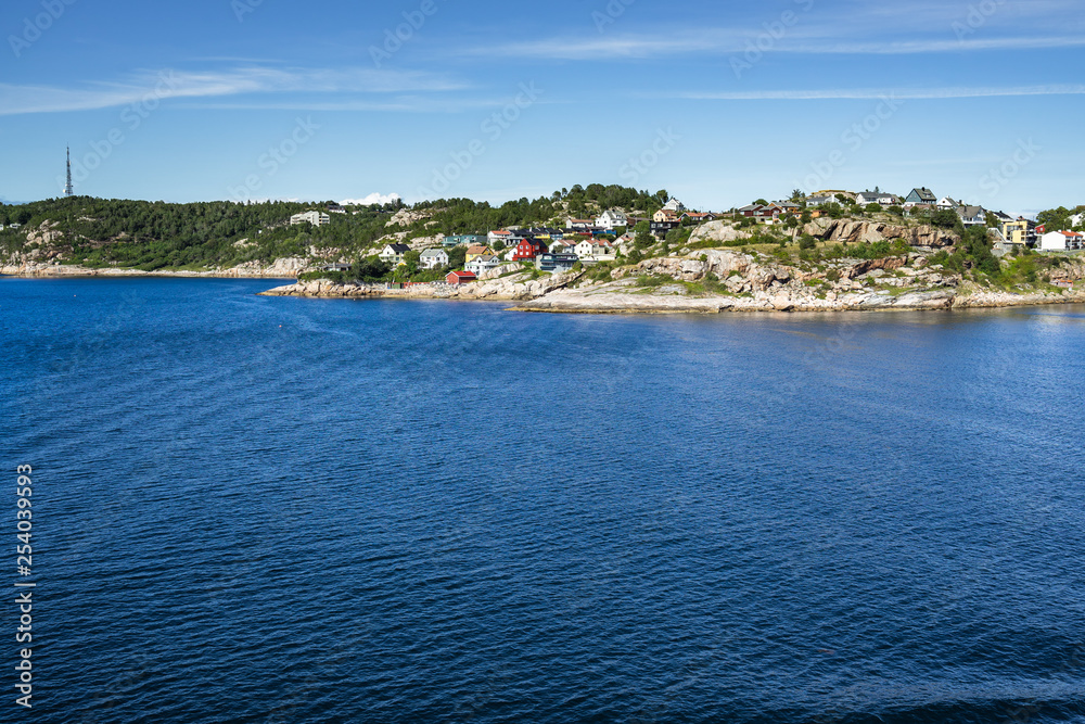 Coastline near Kristiansund in a bright sunny day with typical colorful houses, Norway.