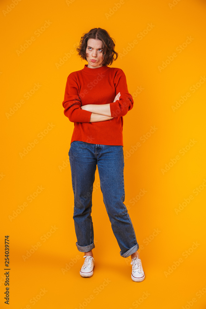 Angry displeased young pretty woman posing isolated over yellow wall background. Angry displeased young pretty woman posing isolated over yellow wall background.