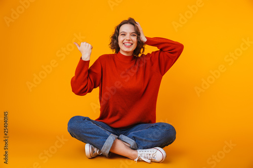 Emotional young pretty woman posing isolated over yellow wall background showing copyspace. © Drobot Dean