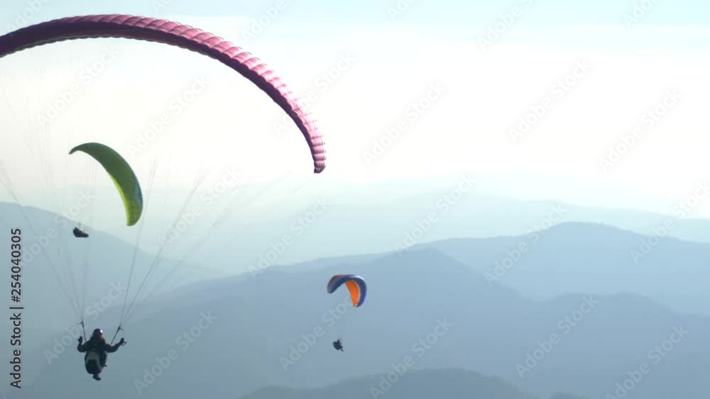Paragliders flying over mountains. Group of paragliders in air, Slovenia. Paragliders flying over mountains. Group of paragliders in air, Slovenia.