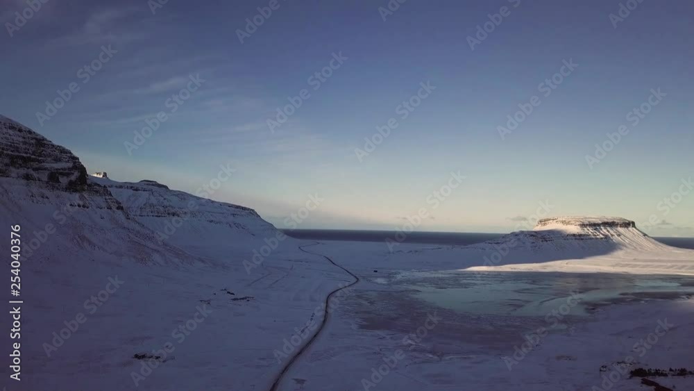 Aerial dolly forwards, road leading through snowy Icelandic landscape. Aerial dolly forwards, road leading through snowy Icelandic landscape.
