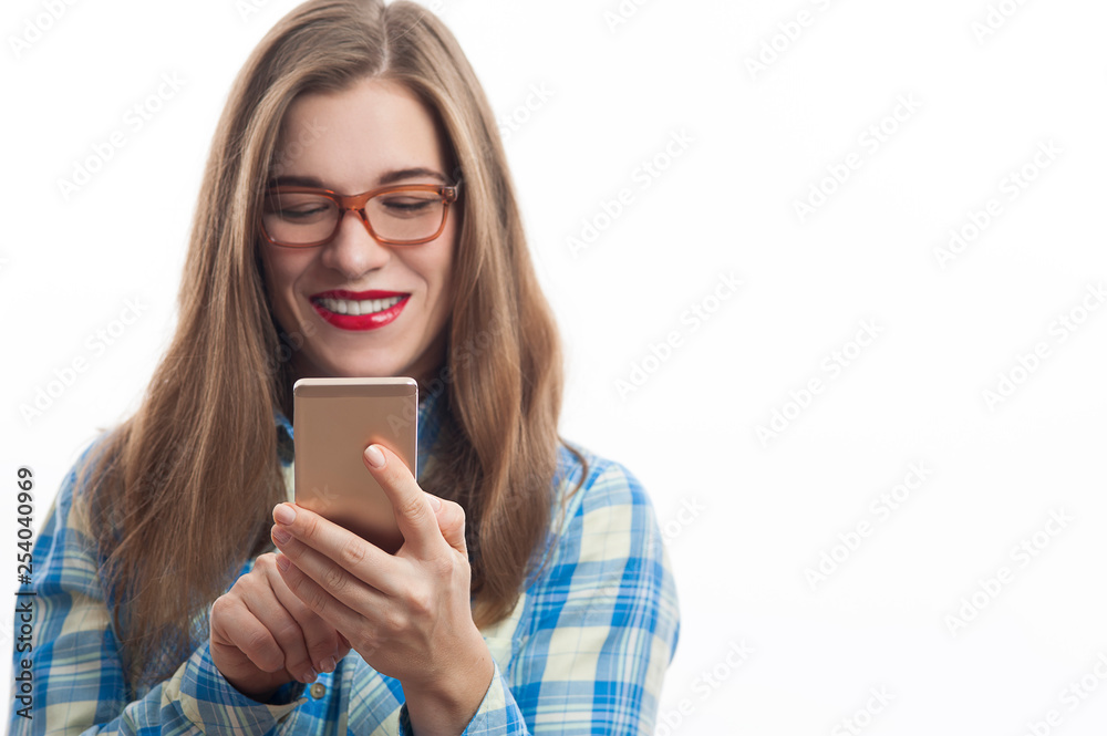 Young beautiful female in plaid shirt using her mobile phone