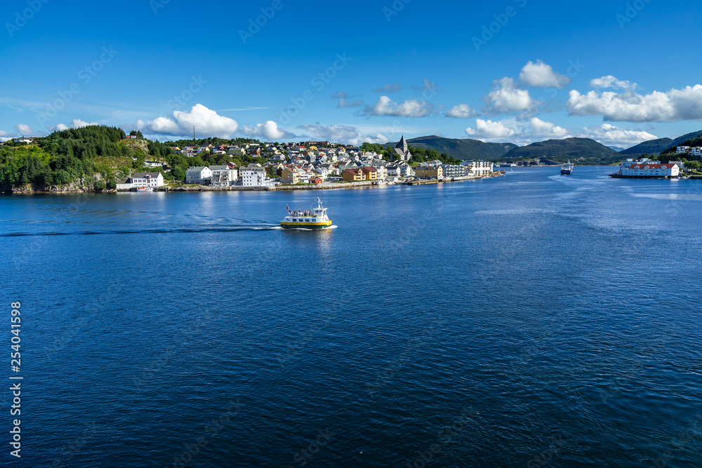 Colorful ferry boatwith the city of Kristiansund in the background, More og Romsdal, Norway Colorful ferry boatwith the city of Kristiansund in the background, More og Romsdal, Norway