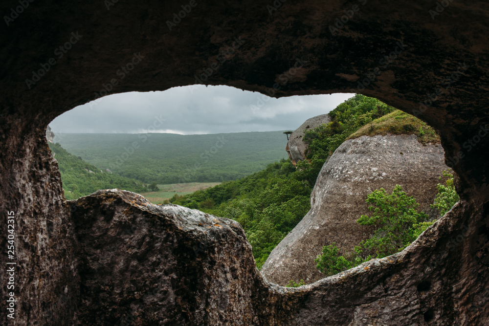 View from the ancient cave to the green mountain forest valley. Landscape in the Crimean mountains