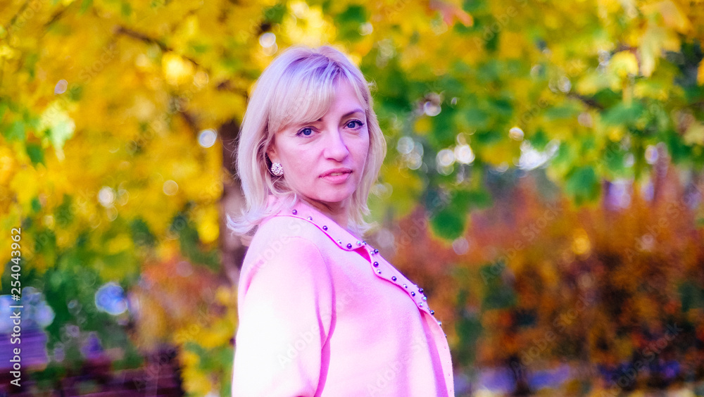 woman in the Park in a pink wool jacket enjoys the sun and enjoys life woman in the Park in a pink wool jacket enjoys the sun and enjoys life