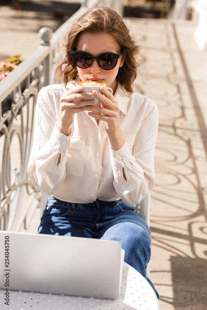 Fototapeta premium Smiling young businesswoman sitting at the cafe