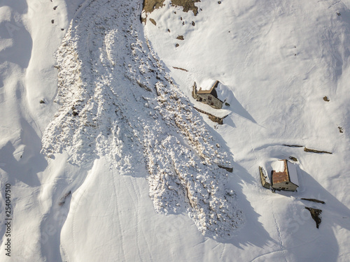 Fotografering Aerial view of snow avalanche on mountain slope