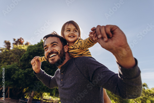 Smiling man playing with his kid outdoors