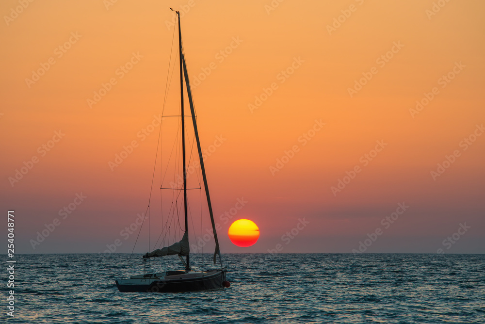 Ein Segelboot bei Sonnenuntergang am Meer