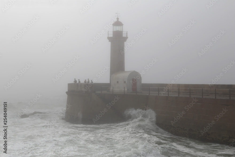 Lighthouse in the fog in stormy weather