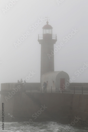 Lighthouse in the fog in stormy weather