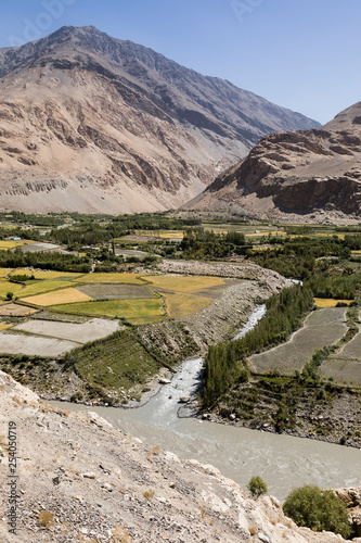 Fertile Wakhan Valley with Panj river near Vrang in Tajikistan. The mountains in the background are the Hindu Kush in Afghanistan photo