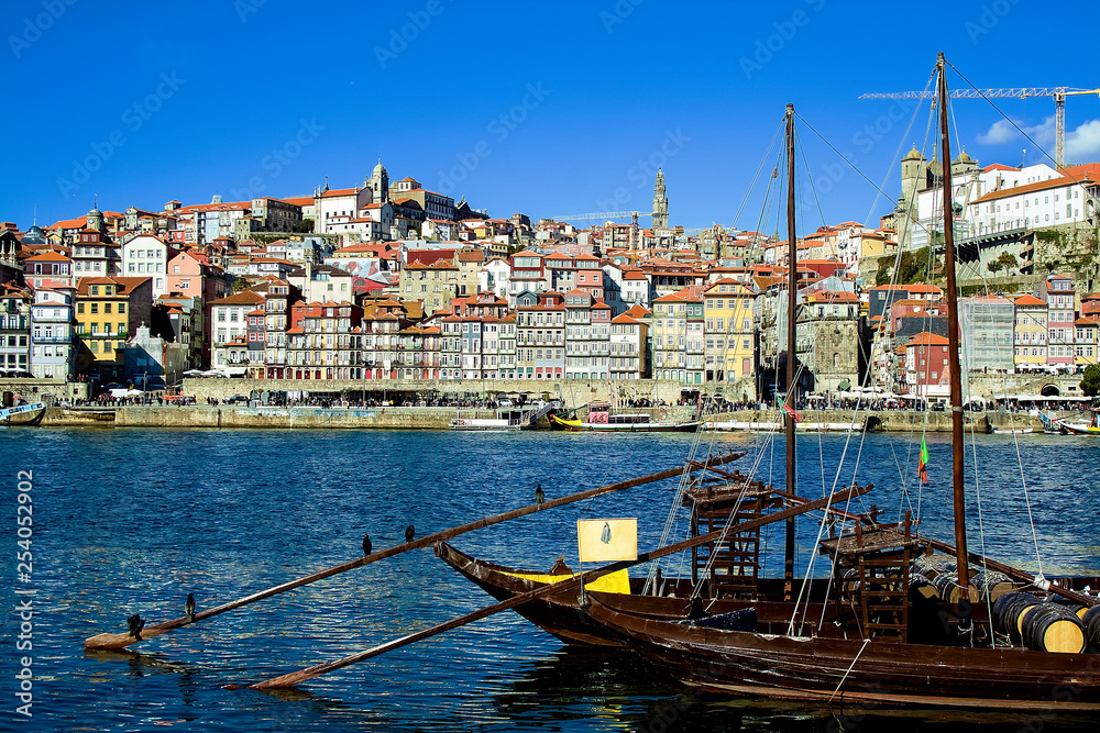 View from the side to the boat on the river, behind the backdrop of the city. Porto, Portugal.