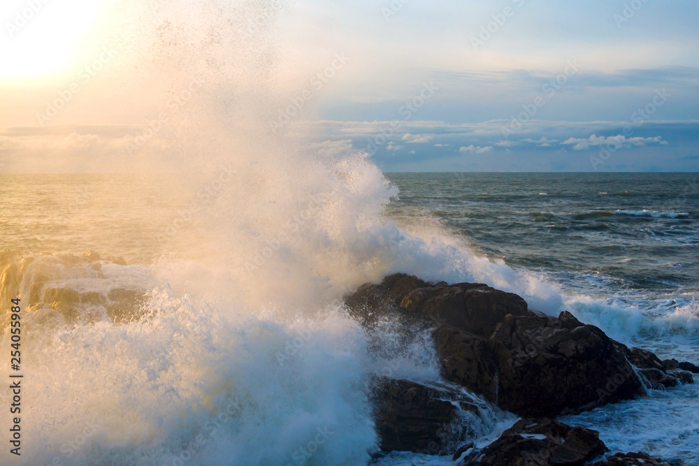 Seascape. Waves of the Atlantic Ocean crashing against a rock at sunset. Portugal