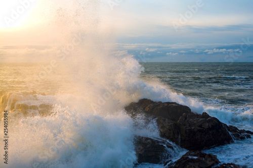 Seascape. Waves of the Atlantic Ocean crashing against a rock at sunset. Portugal