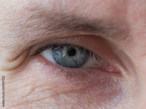 Wrinkles in the eyes of a man of age. Close up.