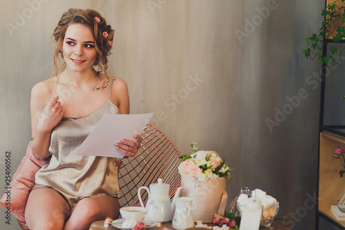 young woman sitting at home in a chair at Breakfast and reading. 