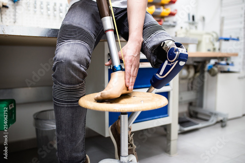 Konstfotografi Disabled man working in amputee shop for production prosthetic extremity parts