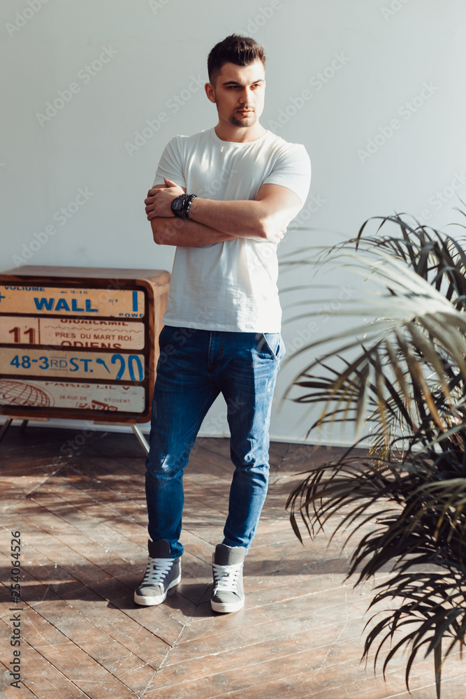 Fototapeta premium man in t-shirt and jeans standing in loft room