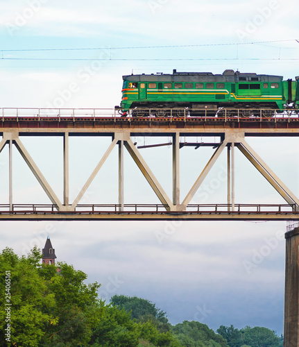 Green Cargo Locomotive Rides on a High Bridge Over the River