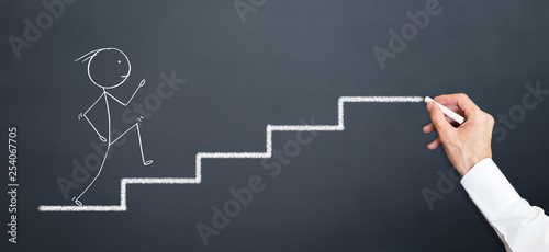 leader draws stairs on blackboard with chalk. man climbing stairs