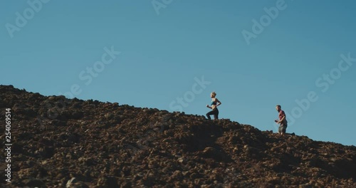 Trail running in the mountains, young athletic man and woman working out in the outdoors, running adventure lifestyle