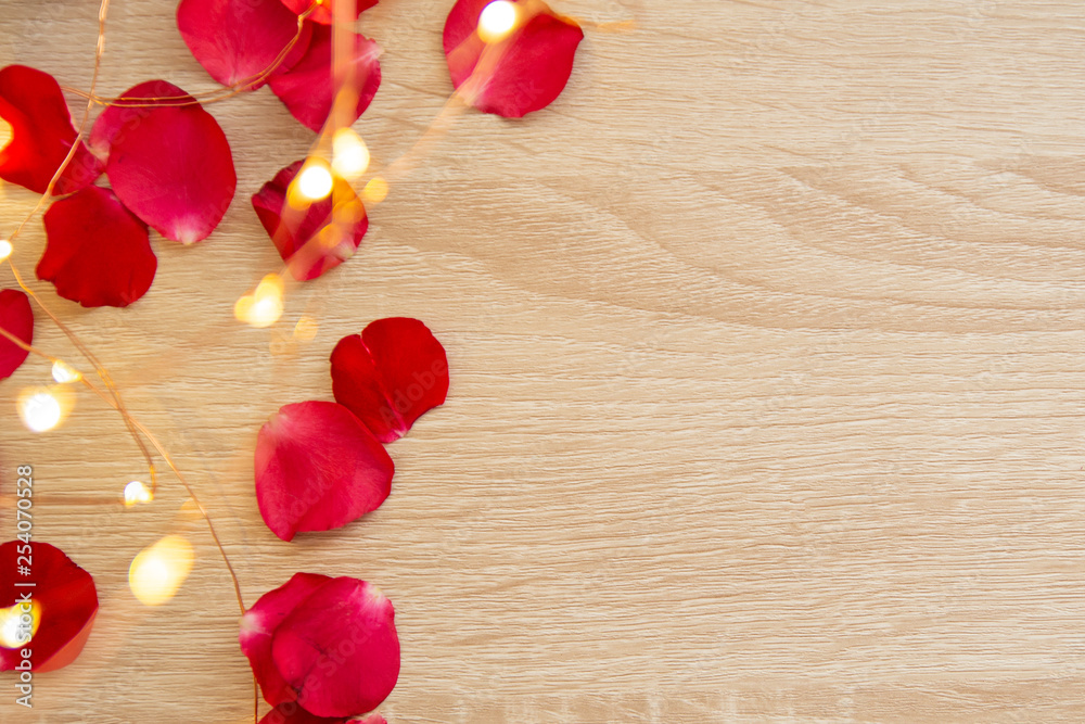 valentines day background with red rose petals on vintage wooden table valentines day background with red rose petals on vintage wooden table