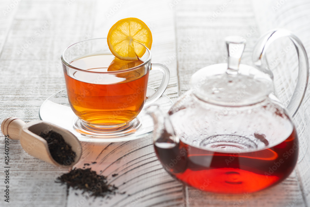 Transparent teapot with red (black) tea on the table Transparent teapot with red (black) tea on the table