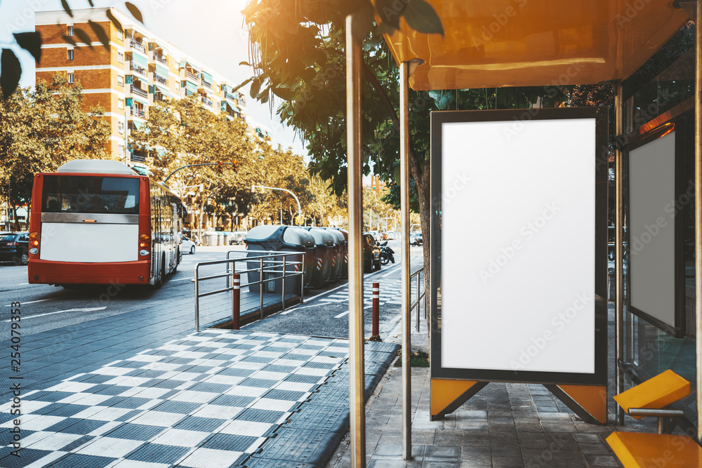 The bus stop with departing red bus and with blank poster mock-up inside;  an advertising