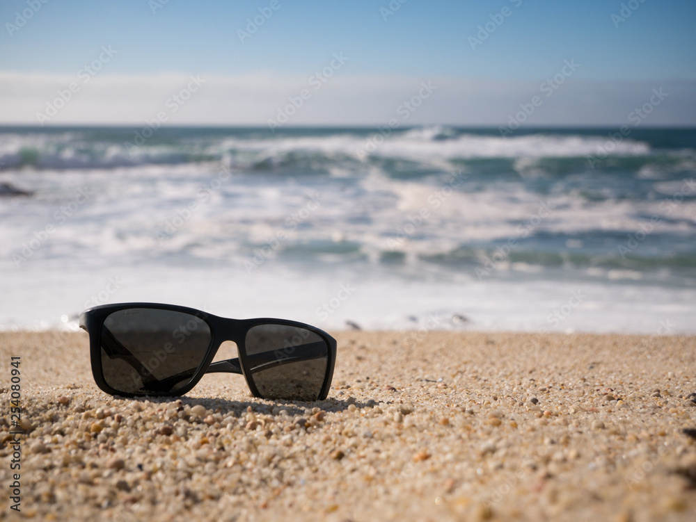 Sunglasses lying on sandy beach. shallow depth of field. Sunglasses lying on sandy beach. shallow depth of field.
