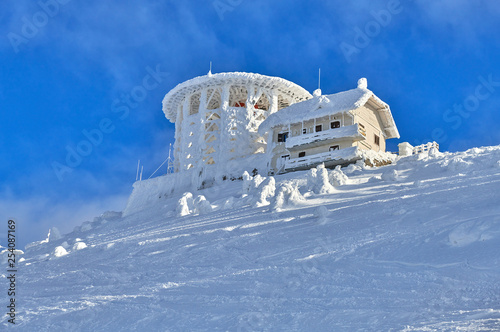 Panoramic view over the ski slope Poiana Brasov ski resort in Transylvania, Pine forest covered in snow on winter season,Mountain landscape in winter