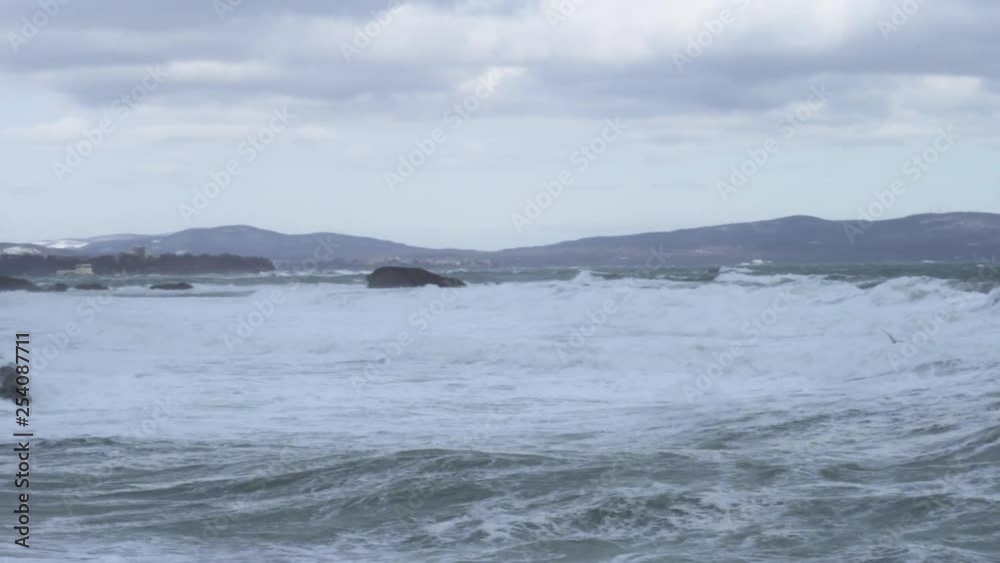 Panning shot of winter rocky sea coast in high wind and big waves Panning shot of winter rocky sea coast in high wind and big waves