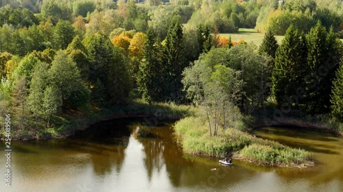 Fishermen on a rubber boat on a lake Kirkilai, autumn landscape. Lithuania, Birzai. photo