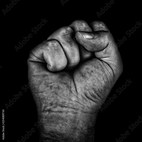 Aggressive black and white adult male clenched fist isolated on a black background