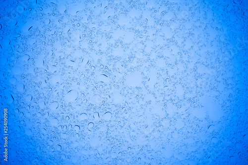 Rain droplets on blue glass background, Water drops on blue glass.